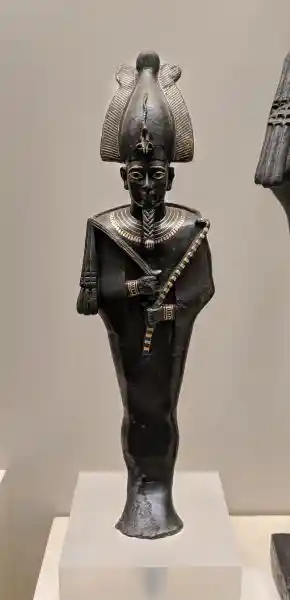 Ancient Egyptian copper alloy statuette of Osiris with rich gold inlay on crown, collar, and regalia
